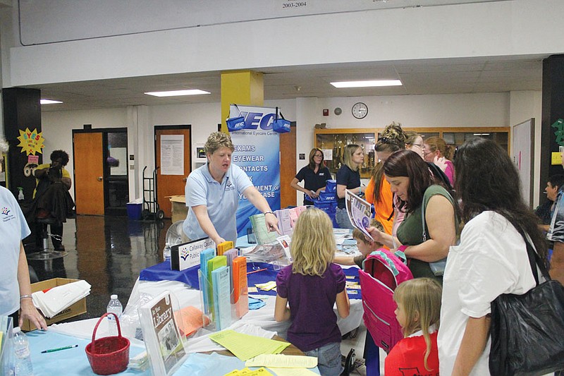 A group of students and parents crowd around a table where Callaway County Public Library employees disperse school supplies and library  resources at the Back to School Fair. More than 700 people took advantage of the free fair, which gave out school supplies, dental screenings and more to make sure students were prepared for the school year ahead.
