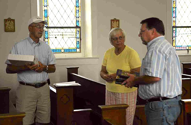 Friends of Cedron volunteers Jim Imhoff, Teresa Kirchhoff and Tim Imhoff discuss plans for the Welcome Back to Cedron noon Mass Sunday, Aug. 18, 2013, at the restored Assumption Catholic Church.  