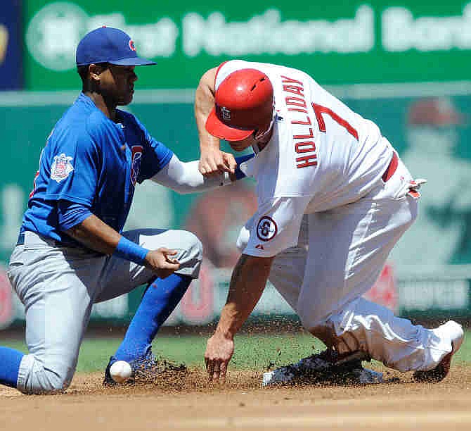 St. Louis Cardinals' Matt Holliday (7) steals second as Chicago Cubs' Starlin Castro, left, cannot make the tag in the first inning in a baseball game on Sunday, Aug. 11, 2013, at Busch Stadium in St. Louis.