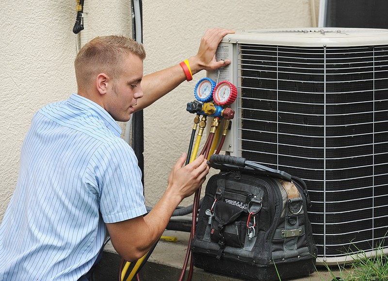 Billy Schafer, a veteran service technician with Aire Serve Heating and Cooling, checks the coolant level on an air conditioning unit. Aire Serve is an authorized contractor for installation in Ameren UE's Coolsavers program.
