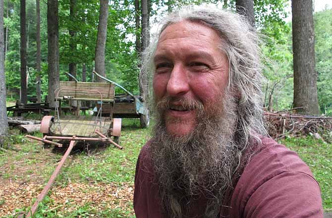 Eustace Conway sits near horse-drawn farm implements at his Turtle Island Preserve in Triplett, N.C., on Thursday, June 27, 2013. People come from all over the world to learn natural living and how to go off-grid, but local officials ordered the place closed over health and safety concerns. 
