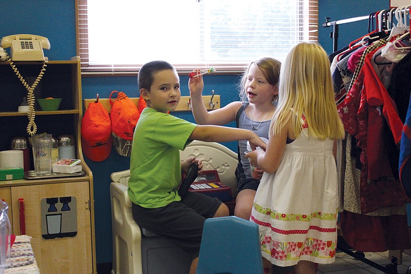 From left: Christian Moore, Abby Schmidt and Megan Schmidt play with toys during the T-Bird Preschool open house Monday.