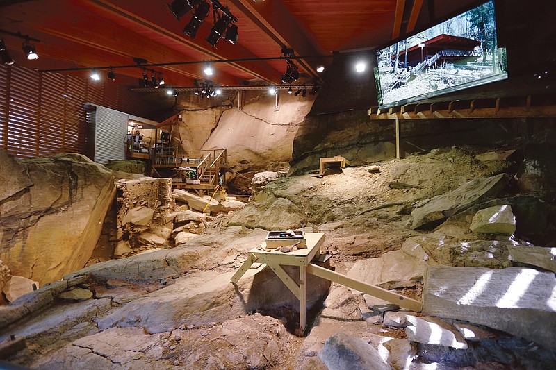 A video display showing the exterior of the shelter is seen is seen above  the archeological dig at the Meadowcroft National Historic Site.
