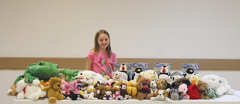 Lydia Books, 10, stands with the dozens of stuffed animals she helped collect to donate to the Fulton Police Department to give to children in crisis. Instead of presents, Books asked guests to her birthday party to bring a stuffed animal for the cause. The Fulton Rotary Club also assisted in collection.