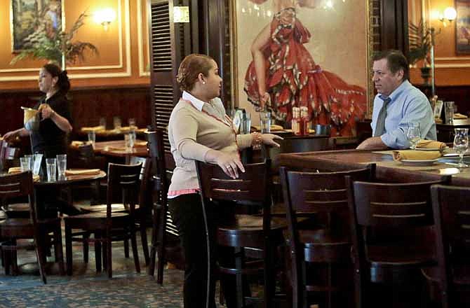 In this Thursday, Aug. 8, 2013, photo, Jeremy Merrin, right, owner of Havana Central restaurants, listens during a conversation with Rosalyn Rentas, general manager, in New York. Merrin said that while he supports healthcare reform, the current changes under President Obama will hurt small businesses like his.