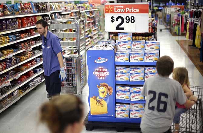 In this Friday, July 12, 2013, file photo, shoppers peruse the aisles at a Wal-Mart in Bristol, Pa. Americans increased their spending at an annual rate of just 1.8 percent in the April-June quarter, down from a 2.3 percent rate in the January-March period. Consumer spending is expected to improve in the second half of the year. But most economists foresee only a slight acceleration to an annual rate of 2 percent to 2.5 percent.