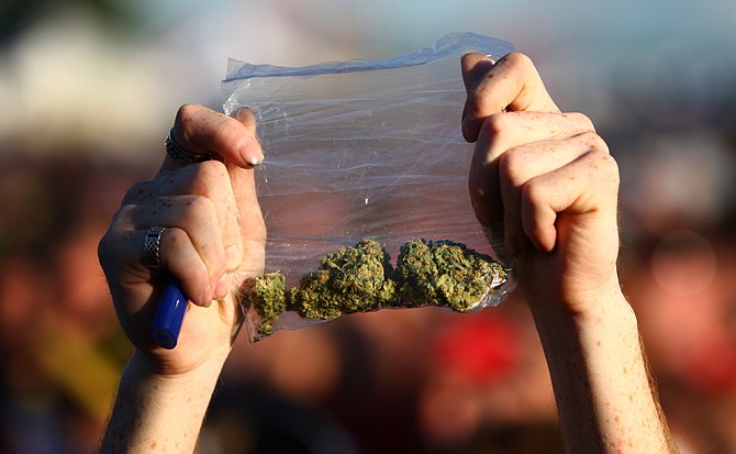 A participant holds up a bag of marijuana during the first day of Hempfest 2011, a gathering of thousands of people at Myrtle Edwards Park in Seattle. Tens of thousands are expected to attend Hempfest this weekend, even though marijuana is newly legal in Washington state. Some wonder if the festival is becoming irrelevant, but organizers argue they still need to change minds nationally, and the festival is a good place to start.