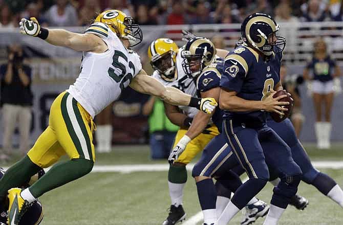 Green Bay Packers outside linebacker Clay Matthews, left, reaches for St. Louis Rams quarterback Sam Bradford during the second quarter of an NFL football game on Saturday, Aug. 17, 2013, in St. Louis.