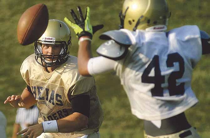 
Helias quarterback Wyatt Porter pitches the ball to running back Nik McCurren on an option play during the Crusaders' intrasquad scrimmage Saturday night.