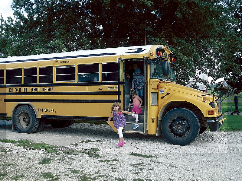 
Kindergartner Adalynn Robb bounces off the school bus with a smile for her first day of school at High Point Thursday, Aug. 15, 2013.