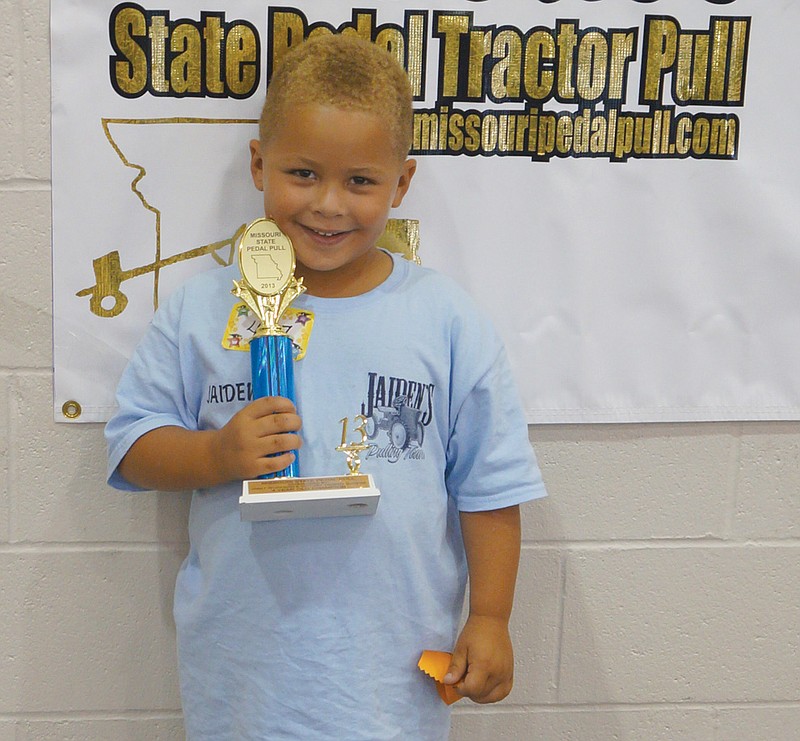 Jaiden Galbreath of Calwood poses with his first-place trophy at the Missouri State Fair's State Pedal Tractor Pull held Sunday. In Galbreath's first year as a pedal pull competitor, he took first at both the Callaway County Fair and State Fair, and will represent his age division in national competitions in September.