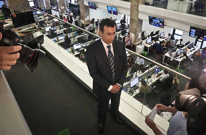 Ehab Al Shihabi, interim CEO for Al-Jazeera America, listens during an interview overlooking the newsroom, after the network's first broadcast on Tuesday, Aug. 20, 2013 in New York. The Qatar-based Al-Jazeera Media Network launched its U.S. outlet only eight months after announcing the new venture, which on Tuesday replaced Al Gore's Current TV in more than 45 million TV homes. 