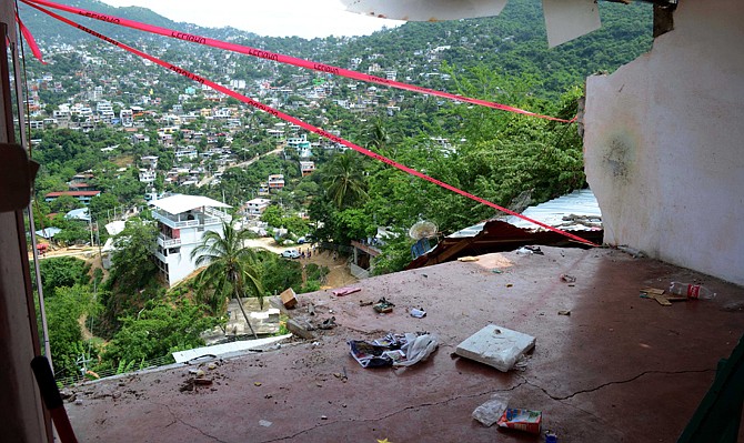 The wall of a home is missing after it fell during an earthquake in Acapulco, Wednesday, Aug. 21, 2013. The U.S. Geological Survey said the quake had a magnitude of 6.2 and was centered on the Pacific coast, near the resort of Acapulco. 