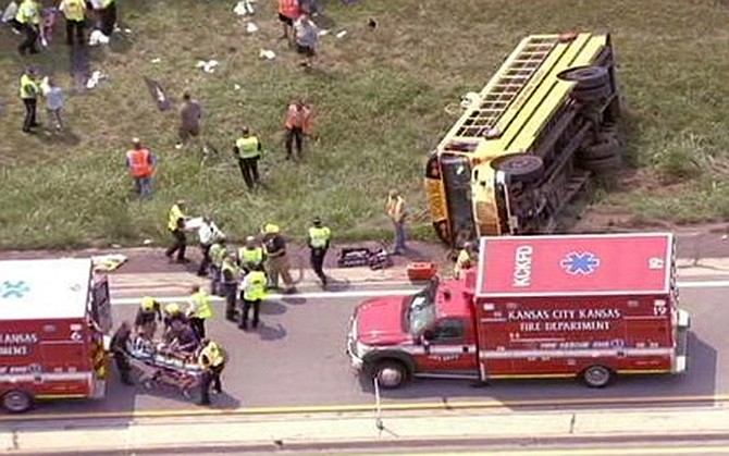 This image from video provided by KMBC-TV shows the scene of a school bus crash Wednesday, in Bonner Springs, Kan. A spokeswoman for a private Kansas City, Mo., school says eight sixth-grade girls have sustained noncritical injuries after their school bus overturned in Bonner Springs, Kan. The spokesperson says the bus was carrying 30 girls to a campout. 