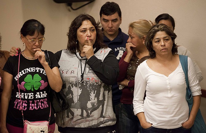 Family members of youth who disappeared in May from a Mexico City nightclub listen to prosecutor Rodolfo Rios at a press conference regarding a mass grave that was found in Mexico City, Thursday.  