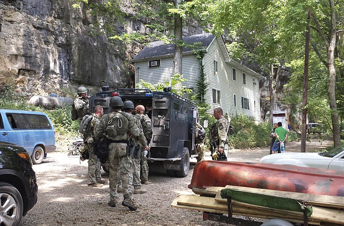 Law enforcement officers execute a search warrant on Aug. 22, 2103 at a rural Freeburg, Mo., home where they found a suspected methamphetamine lab.