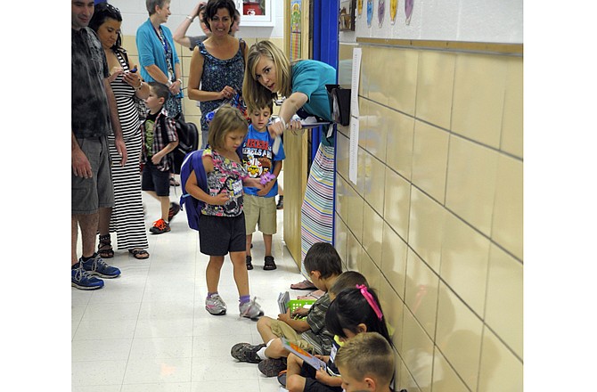 As kindergartners approached Lauren Novak's classroom before their first day of school Thursday, they were directed to pick up a book and wait in the hallway. 