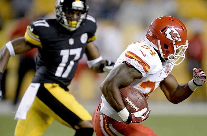 Kansas City Chiefs' Knile Davis (34) returns a kickoff for a touchdown past Pittsburgh Steelers J.D. Woods (17) in the third quarter of an NFL preseason football game Saturday, Aug. 24, 2013, in Pittsburgh.