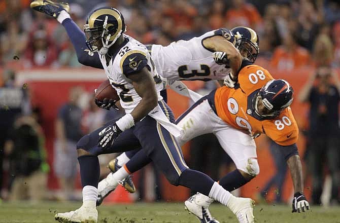 St. Louis Rams linebacker Alec Ogletree (52) runs back an interception as St. Louis Rams cornerback Cortland Finnegan (31) puts a block on Denver Broncos tight end Julius Thomas (80) in the second quarter of a preseason NFL football game, Saturday, Aug. 24, 2013, in Denver.