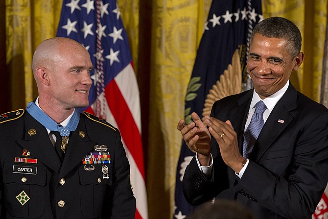 President Barack Obama applauds Monday after awarding US Army Staff Sgt. Ty M. Carter, left, the Medal of Honor for conspicuous gallantry during a ceremony in the East Room of the White House in Washington. Carter is the fifth living recipient to be awarded the Medal of Honor for actions in Iraq or Afghanistan. 