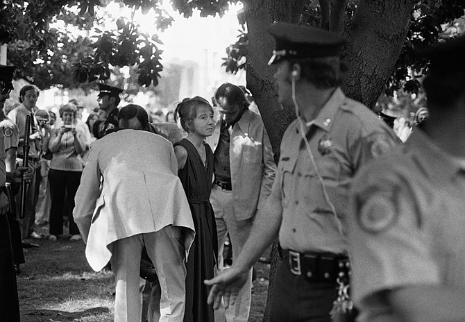 Lynette Fromme, a woman who pointed a gun at President Gerald Ford as he walked from his hotel to the State Capitol in Sacramento, Calif., is taken into custody in this photo from Sept. 5, 1975. Almost 38 years after the assassination attempt, a federal judge has allowed the release of a videotaped testimony given by Ford that was later used in Fromme's trial. 