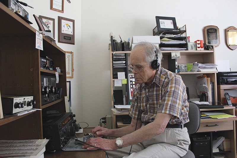 Dick White listens in as he taps out a message in Morse code to a listener across the world from his home Monday. White, perhaps Callaway County's most prolific ham radio operator, has made contacts to almost everywhere in the world over the past 37 years.
