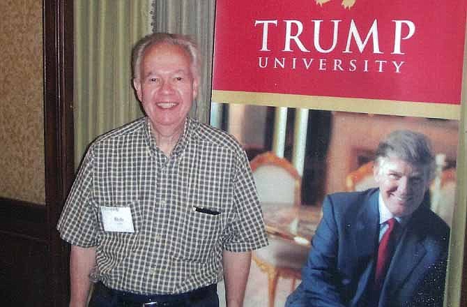 In this undated photo provided by Bob Guillo, Guillo poses with a cardboard of millionaire/Reality TV Star Donald Trump in New York. Guillo paid $35 thousand to attend a Trump University seminar but never got to meet Trump in person. New York Attorney General Eric Schneiderman filed a $40 million lawsuit against the billionaire developer and his "Trump University." 
