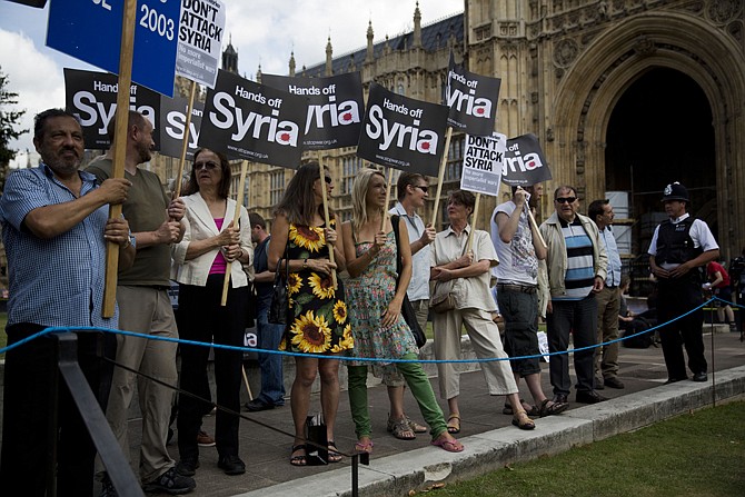 People take part in a protest Thursday in London, calling for no military attack on Syria from the U.S., Britain or France, organized by the Stop the War coalition and timed to coincide with a debate and vote by politicians.