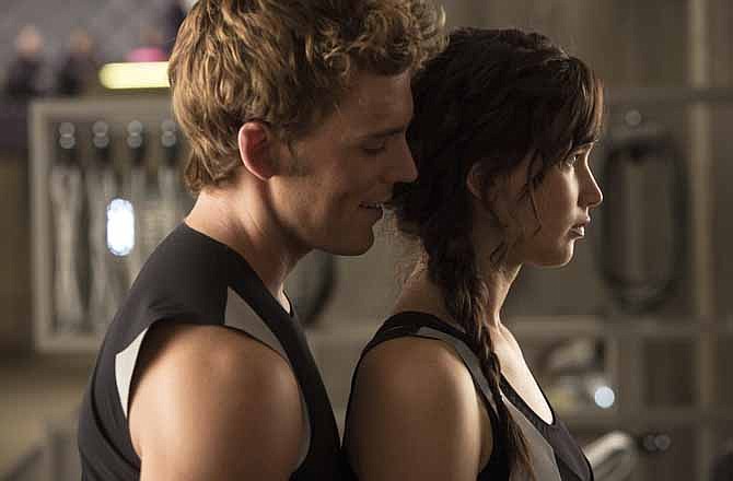 This film image released by Lionsgate shows Sam Claflin, left, and Jennifer Lawrence in a scene from "The Hunger Games: Catching Fire."