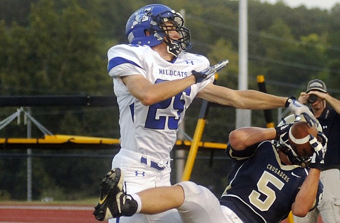 Helias running back Brock Gerstner hauls in a pass over Harrisonville linebacker Tryston Jackson, but comes down just out of bounds Friday night at Adkins Stadium.