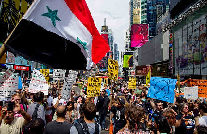 Opponents of U.S. military action in Syria demonstrate at New York's Times Square on Saturday, Aug. 31, 2013. Protesters around the world took to the streets Saturday to protest for and against a possible U.S.-led attack on Syria as President Barack Obama announced he would seek congressional approval for such a move. 