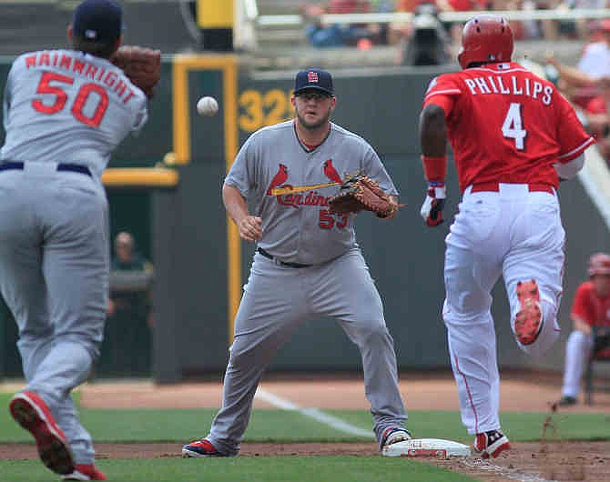 St. Louis Cardinals' Adam Wainwright throws the ball to first baseman Matt Adams to force out the Cincinnati Reds' Brandon Phillips as he bunted to move base runner Shin Soo Choo to second base in the first inning in their baseball game in Cincinnati, Monday Sept. 2, 2013. 
