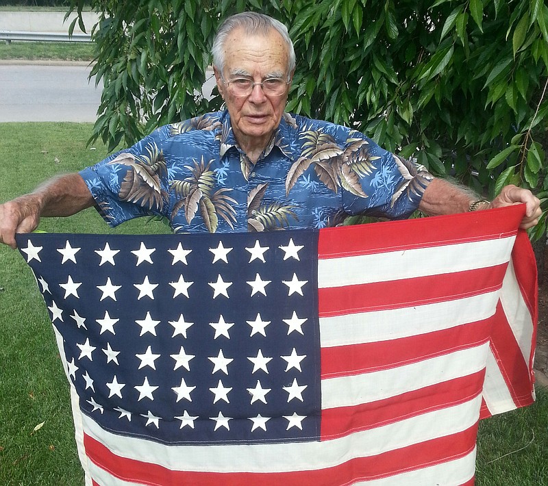 Local veteran Harold Markway displays a 48-star U.S. flag he acquired while serving in the Navy during World War II. After returning from the war, Markway went on to own and operate the Welcome Inn in Jefferson City for many years. 