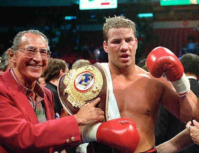 In this June 7, 1993 file photo, newly crowned WBO heavyweight champion Tommy Morrison receives his championship belt after defeating George Foreman in Las Vegas, Nev. Morrison, a former heavyweight champion who gained fame for his role in the movie "Rocky V," has died. He was 44. Morrison's former manager, Tony Holden says his longtime friend died Sunday night, Sept. 1, 2013, at a Nebraska hospital. 