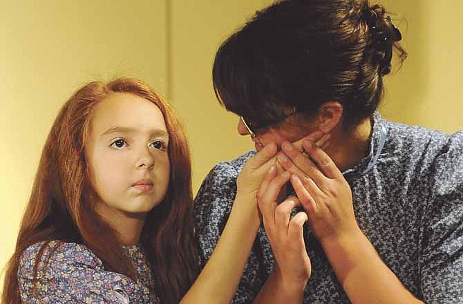 Helen Keller, played by Emily Thompson, touches the face of her instructor and companion Anne Sullivan, played by Kayla Norton, during rehearsal for the Stained Glass Theatre's upcoming performance run of "The Miracle Worker."