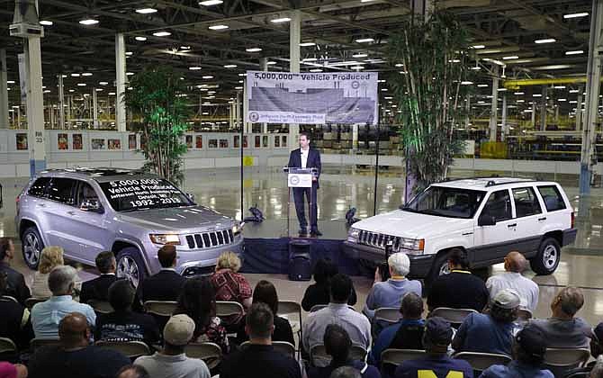 In this Aug. 13, 2013 file photo, Scott Garberding, senior vice president of manufacturing for Chrysler Group LLC stands between a 1992 Grand Cherokee, right, and the automaker's 5,000,000th vehicle produced at the Jefferson North Assembly Plant in Detroit.