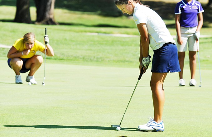Fellow golfers watch as Lauren Plunkett of Helias putts on the seventh hole Wednesday in the Helias Invitational at Meadow Lake Acres Country Club in New Bloomfield.