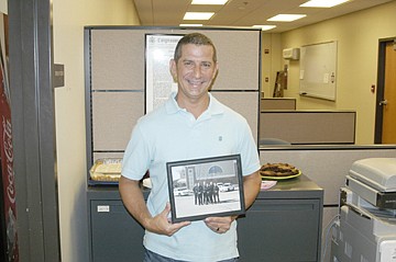 Officer Lindell Reed, California Police Department, holds a photo given during the lunch given as he leaves the department to take another position. He will continue to serve the city as a Reserve Officer.  