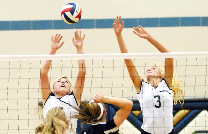 Helias teammates Lindsey Griggs (left) and Erica Haslag go up for a block during Thursday night's match against Lebanon at Rackers Fieldhouse.