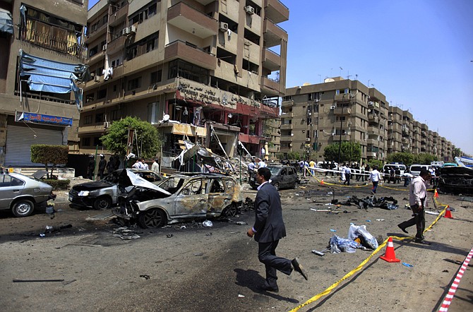 Egyptian security officers gather Thursday at the scene of a bomb attack targeting the convoy of Egypt's Interior Minister Mohammed Ibrahim, in Nasr City, Cairo, Egypt. A "large" explosive targeted the convoy, the first attack on a senior government official since a coup toppled the country's Islamist president two months ago.