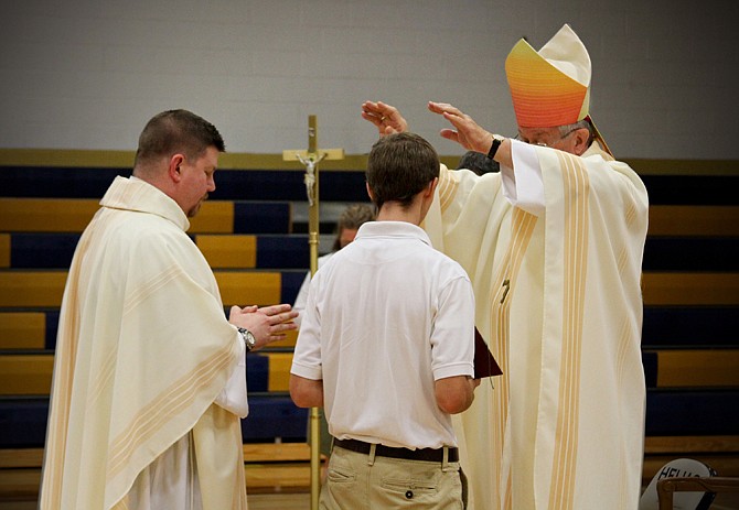 Bishop John Gaydos, right, gives his blessing Thursday on Father Stephen Jones as Helias Catholic High Schools' new president. Jones was appointed to the position in June. 