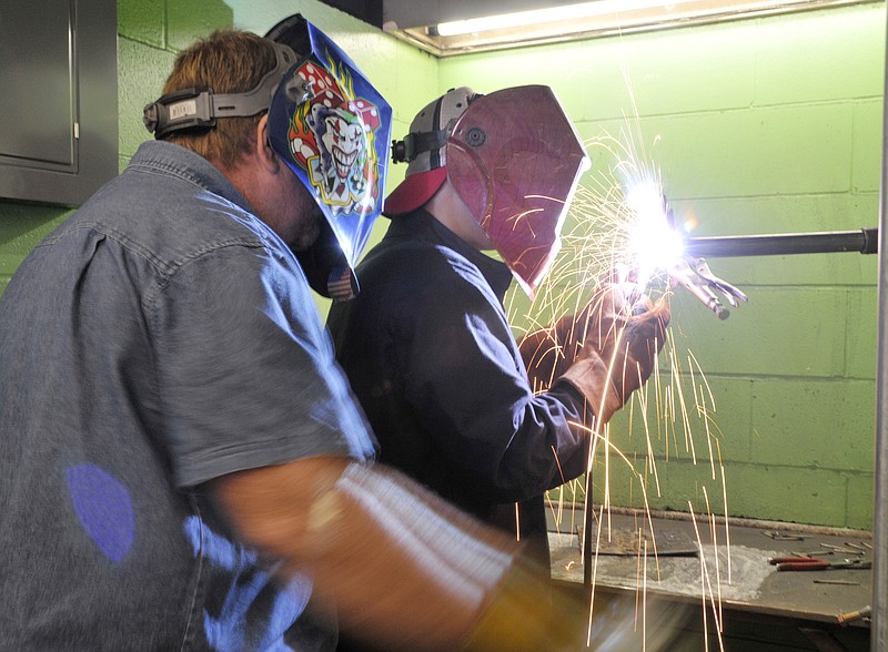 Nichols Career Center welding instructor Ken Thomas watches as Tanner Bennett welds a piece of steel during class Friday. Bennett, a Jefferson CIty High School senior, is in his second year of the class at the local career center. Thomas, who worked at Von Hoffman several years ago, will be in the position to help some of his former co-workers and friends from RR Donnelley as Nichols will be involved in a program to offer an evening course in welding to help some of those employees when to local book printer closes at the end of September. 