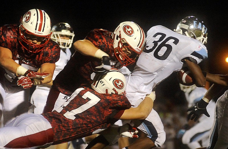 Jefferson City linebackers Travis Burris (47) and Hayden Strobel (52) tackle Belleville East running back DeMarius Ward on Friday night at Adkins Stadium.