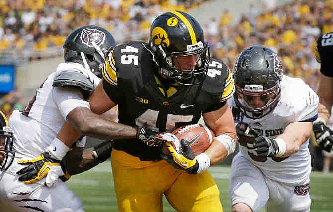 Iowa fullback Mark Weisman, center, scores on a 10-yard touchdown run between Missouri State's Sybhrian Berry, left, and Andrew Beisel, right, during the second half of an NCAA college football game, Saturday, Sept. 7, 2013, in Iowa City, Iowa. Iowa won 28-14. 
