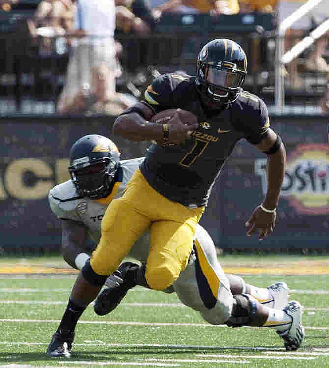 Missouri quarterback James Franklin, right, runs past Toledo's Christian Smith, left, as he scrambles out of the pocket during the first quarter of an NCAA college football game Saturday, Sept. 7, 2013, in Columbia, Mo.