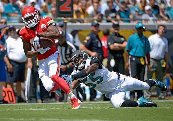 Kansas City Chiefs running back Jamaal Charles, left, runs past Jacksonville Jaguars outside linebacker Geno Hayes (55) during the first half of an NFL football game in Jacksonville, Fla., Sunday, Sept. 8, 2013.