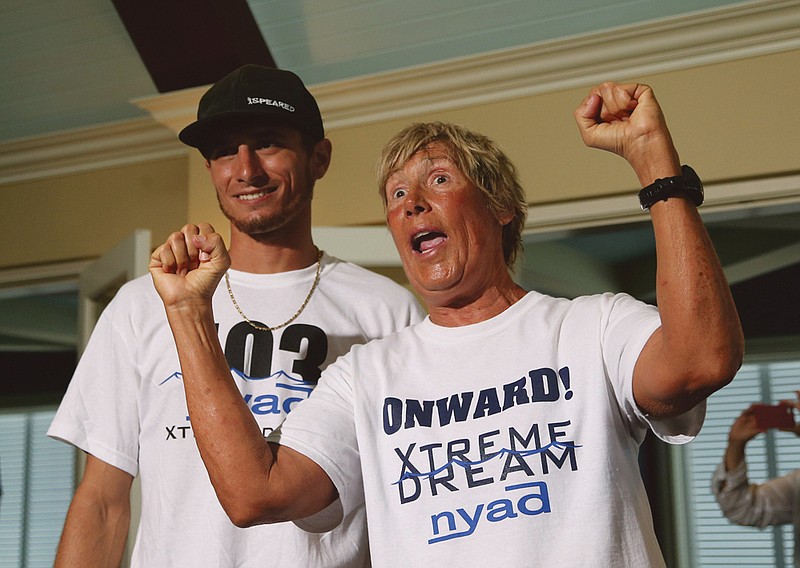 U.S. endurance swimmer Diana Nyad, right, and one her shark divers, Niko Gazzace, celebrate her record-setting swim from Cuba to Florida last Tuesday., talking to the media during a press conference in Key West, Fla. Ny. On social media and an online marathon swimming forum, long-distance swimmers debate whether Nyad got a boost from the boat that accompanied her or if she violated the traditions of her sport by relying on a mask and wetsuit as protection from jellyfish. 