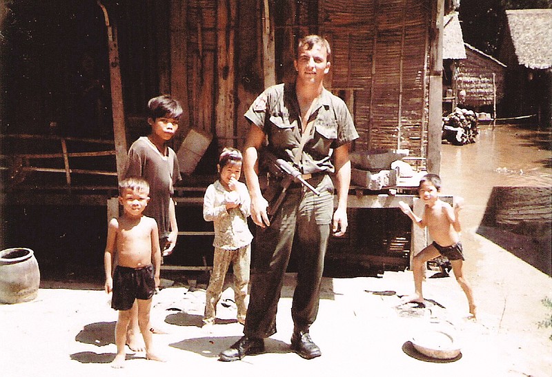 A 1969 photo showing Ward armed with with an M3 "grease gun" and posing with children in a South Vietnamese village while providing security for a team of doctors and combat medics.