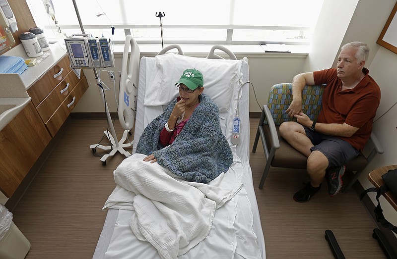 Bev Veals, left, undergoes chemotherapy treatment Aug. 27, accompanied by her husband Scott at Duke Cancer Center in Durham, N.C. Coping with advanced cancer, Veals was in the hospital for chemo this summer when she got a call that her health plan was shutting down.