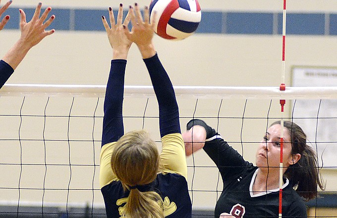 Jefferson City's Becca Sturgess hits into a block by Helias' Brittney Engelbrecht during Tuesday night's match at Rackers Fieldhouse.